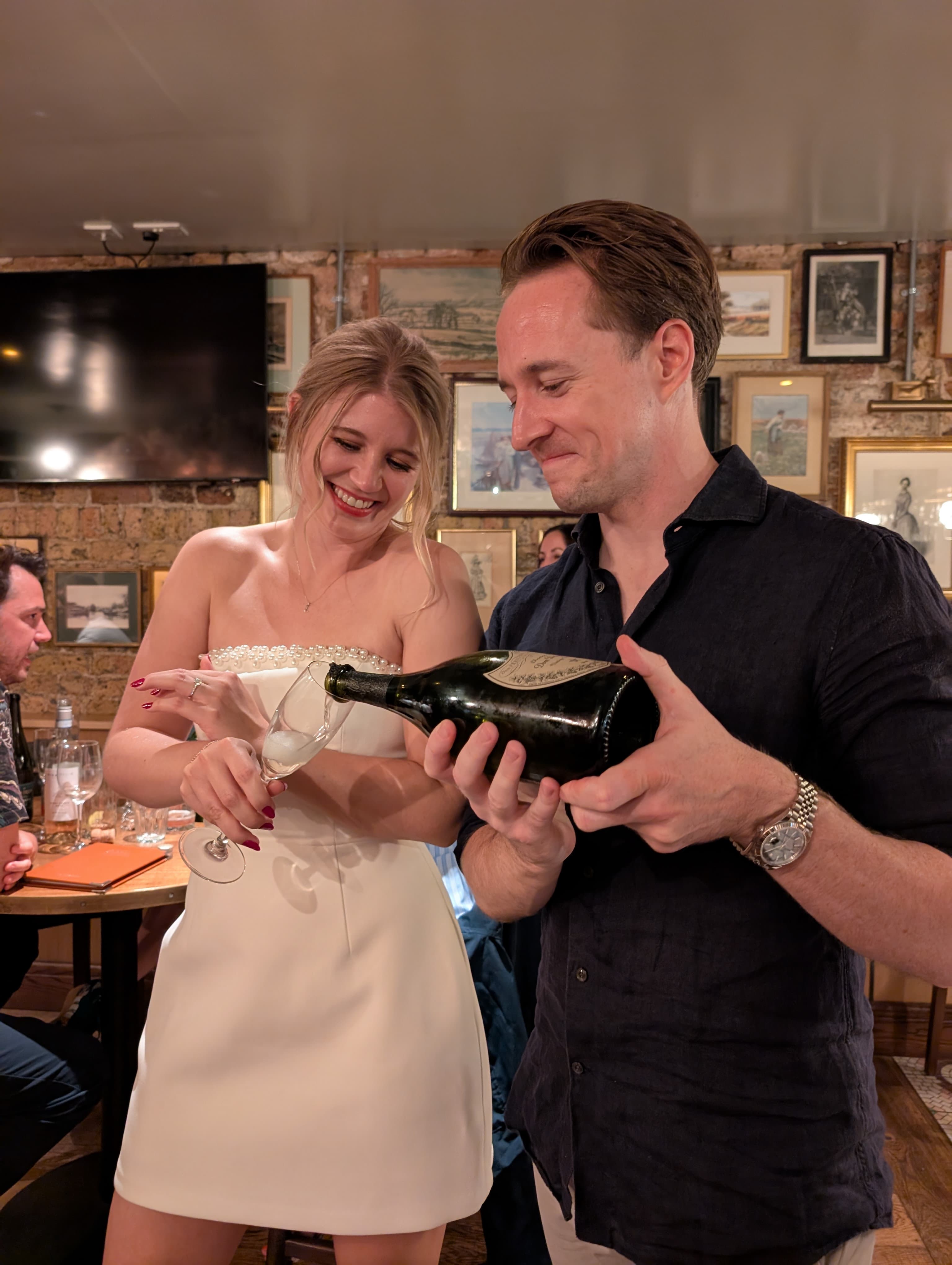 Luther pouring champagne for Alice to celebrate